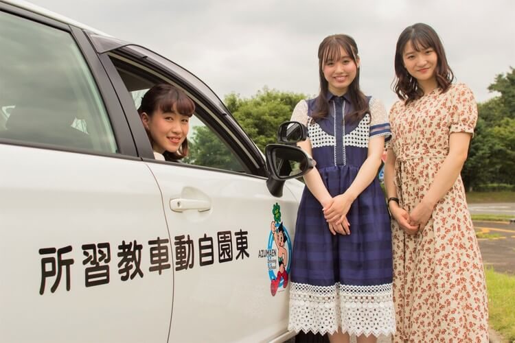 あずまえん自動車教習所の教習車と合宿生2人