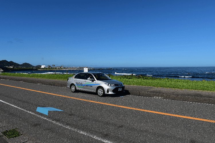 千倉自動車教習所の教習車と海沿いの道