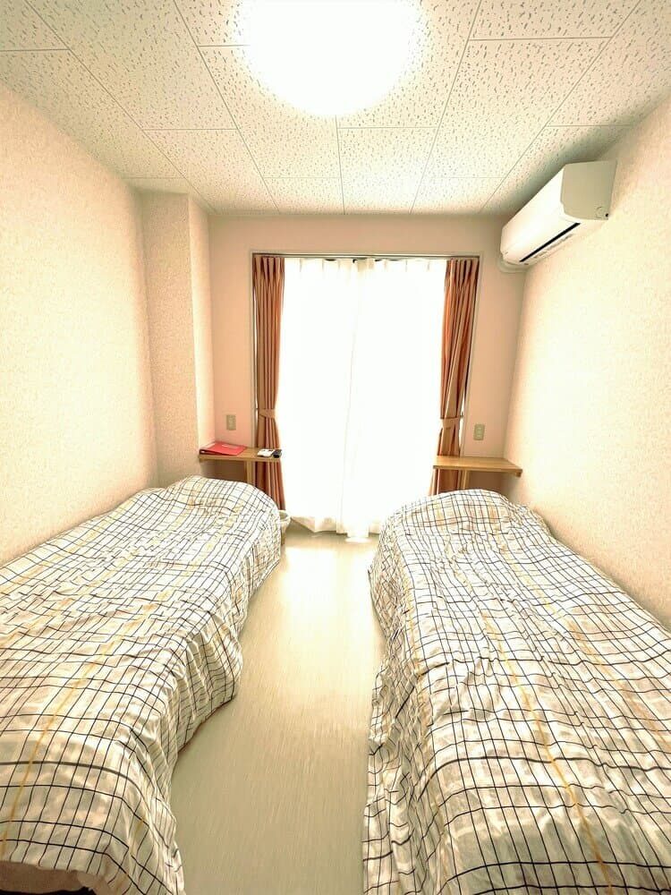 学校寮グレンディール一宮のベッドが2つある部屋