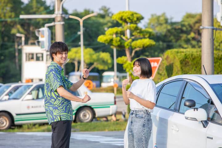 マキオドライビングスクールの合宿生2人と教習車