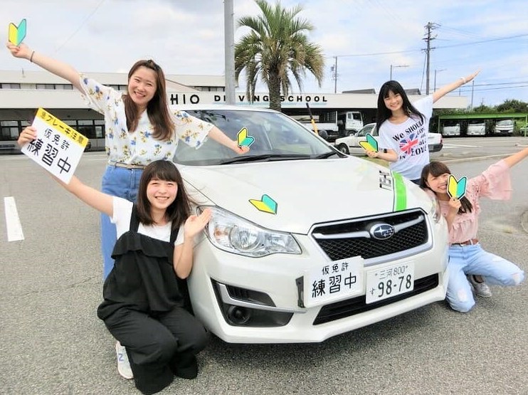 教習車の前に並ぶ西尾自動車学校の教習生