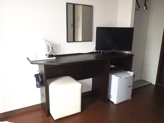 釜石復興ビルの部屋の机とテレビと冷蔵庫